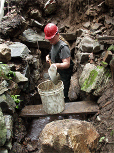 Arron cleans out Feature 19, a tailracechannel just below the Furnace.